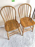 Both matching wooden spindle-back chairs front view