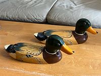 Both wooden mallard decoys side view on table