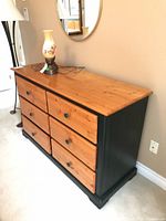 Front three-quarter view showing six drawers, colour contrast, hardware and overall style