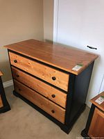 Front view of dresser showing three drawers and contrasting wood tones
