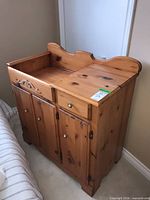 Front view showing doors, knobs, carved apron