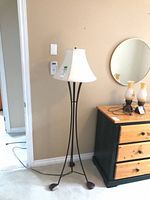 Full view of floor lamp next to dresser