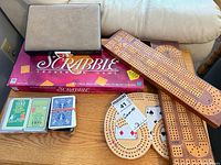 Overall lot showing Scrabble box, cribbage boards, playing cards and closed backgammon case