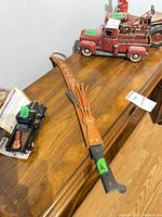 Machete in sheath on wooden surface
