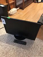 Front view of Sanyo TV with remote on carpet