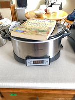 Hamilton Beach slow cooker with cookbook on lid