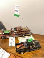 Two metal model vehicles on tabletop, COA visible