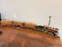 Full train set lined up showing locomotive, tender and three passenger cars