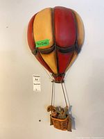 Full view of the carved wood hot air balloon wall art hanging on wall