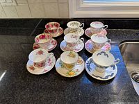 All nine teacup and saucer sets displayed on countertop