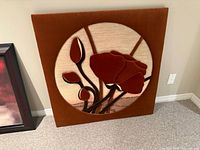 Front view of square rust fabric board with circular poppy textile art