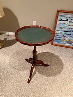 Full view of table showing green leather top and tripod base