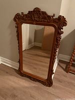 Front view of carved wood mirror showing full frame and glass