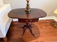 Top view of dark wood drop leaf side table with lamp for scale