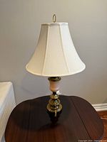 Full view of lamp with shade on wooden table