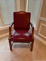 Front view of red leather armchair showing seat, back, arms, legs
