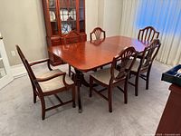 Dining table with one leaf inserted and six chairs around