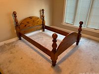 Full view of assembled wood queen bed frame showing cannonball posts
