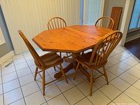 Table with one leaf inserted and four chairs around