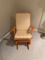 Full front view of wooden glider rocker with striped cushions