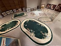 Overview showing six green floral rugs plus grey and beige rugs