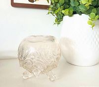 Front view of clear opal glass rose bowl showing pattern and three feet