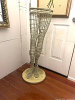 Front view of wicker leg mannequin on base
