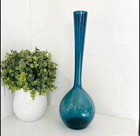 Full view of blue longneck vase on white surface