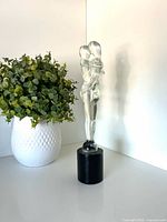 Full view of sculpture beside plant for scale