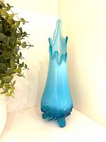 Front angled view of blue opalescent swung vase showing color gradient and rim