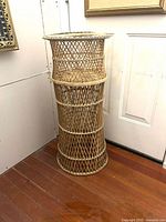 Full view of wicker plant stand showing height and cylindrical form