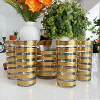 Four highball glasses and ice bucket showing gold band pattern
