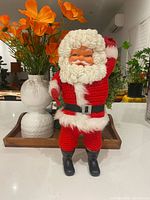 Front view of knitted Santa figure standing on counter