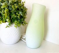 Full view of green frosted glass IKEA Mylonit lamp beside plant