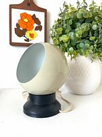 Front view of cream spherical lamp on black magnetic base