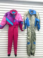 Front view showing both ski suits hanging