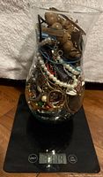 Full view of jar on scale showing mixed jewelry contents