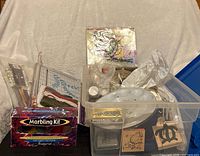 Overall view showing storage bin filled with craft items next to boxed marbling kit and paper trimmer