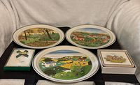 Front view showing three Naif Four Seasons plates, boxed handkerchief and boxed coaster set