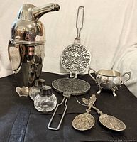 Group shot showing penguin shaker, sugar bowl, crystal shakers, spoons, and press