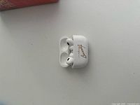 Open AirPods Pro case showing both earbuds inside, Bacardi logo visible