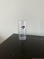 Front view of clear plastic pint glass showing Toronto Blue Jays logo and seam texture