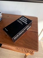 Closed black Cards Against Humanity box on table