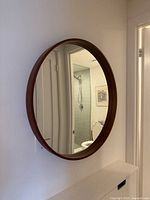 Front view of round oak veneer mirror mounted on wall