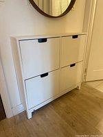 Front view of white IKEA STÄLL shoe cabinet mounted on wall