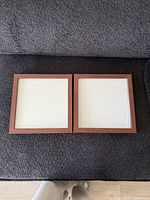 Front view of both square wood frames showing glass and wood finish