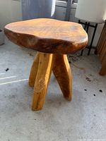 Front view of the wooden stool showing seat and legs