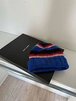 Beanie hat lying on top of original Saint Laurent box