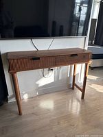 Full view of wood TV stand under mounted television