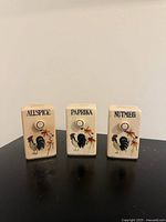 Front view of three spice shakers showing labels and rooster design